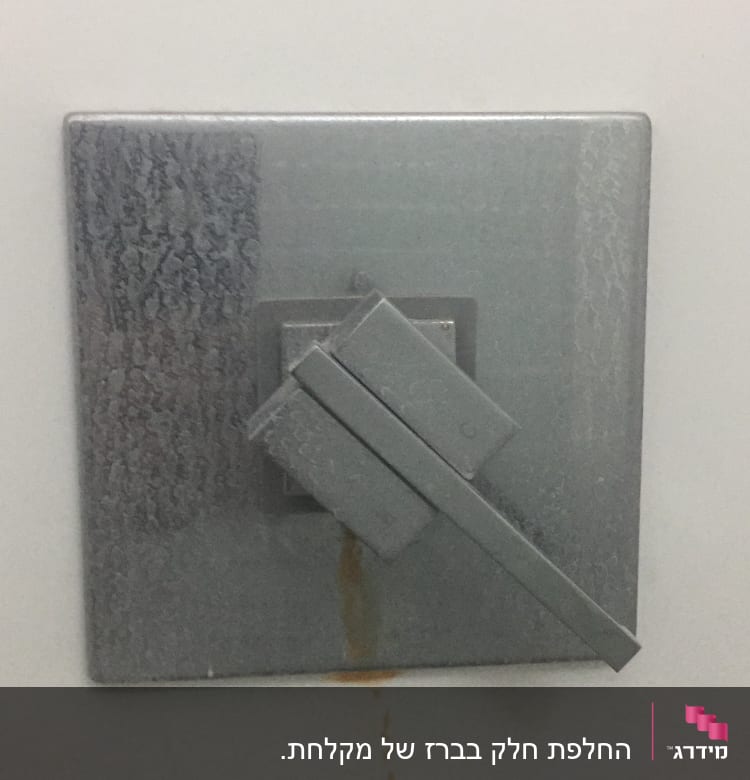 ברז מתכת עם כתמי חלודה על הקיר